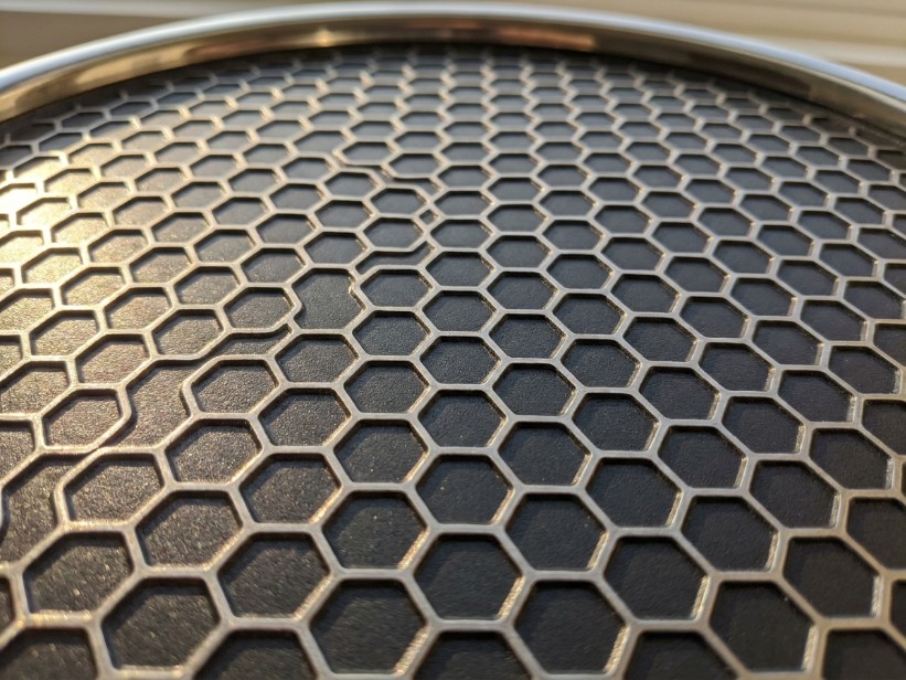 Close-up of hexagonal hybrid cooking surface showing raised stainless steel peaks with dark nonstick valleys
