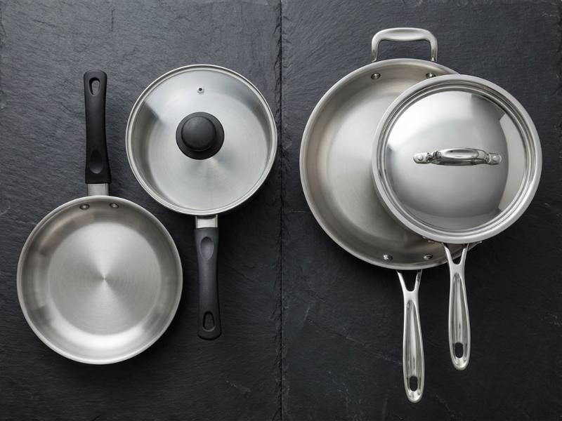 Overhead comparison of budget cookware with plastic handles versus quality set with riveted stainless handles